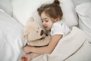 cute-little-girl-is-sleeping-bed-with-teddy-bear-toy-1-
